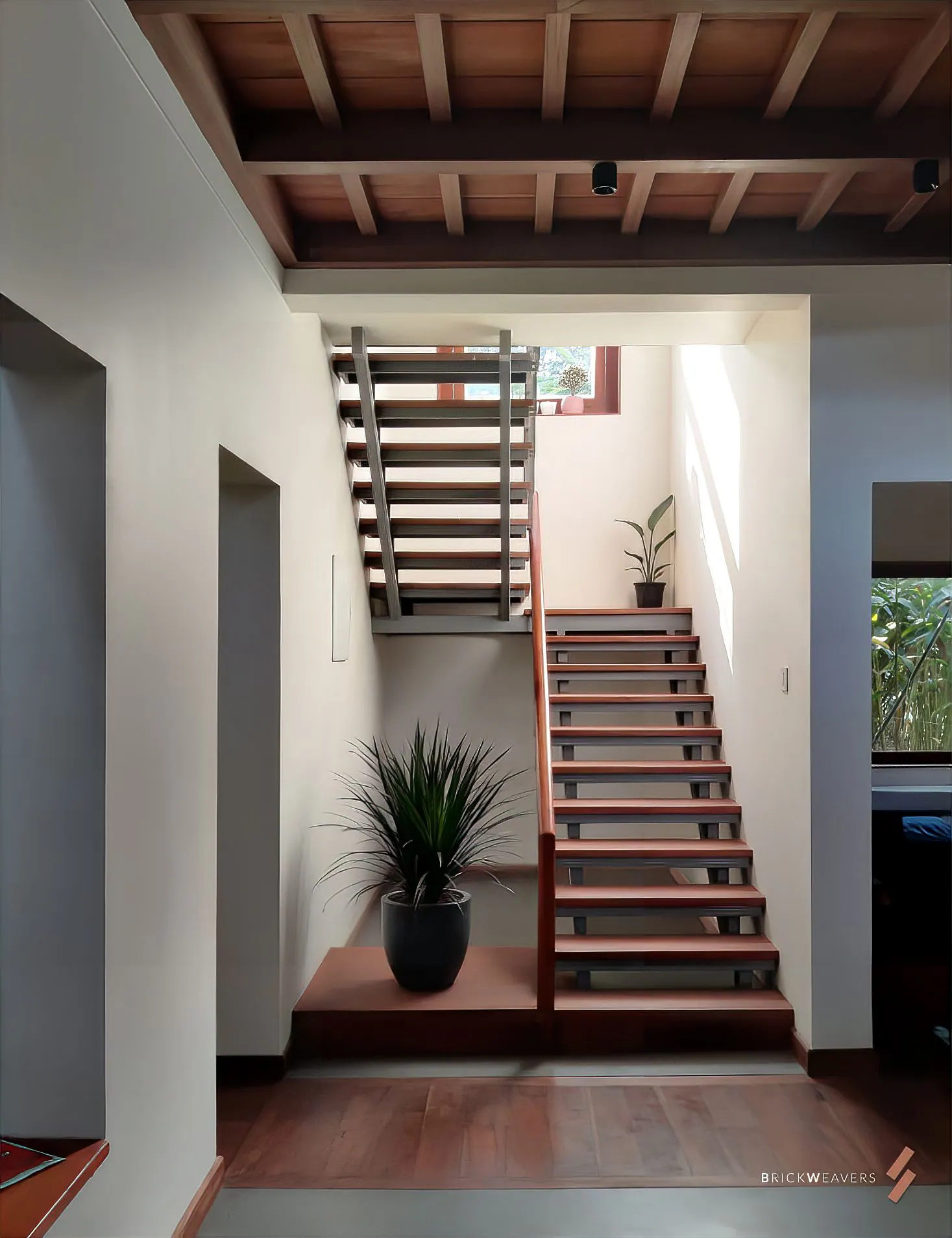 A daylit staircase with plants at Aaranyam